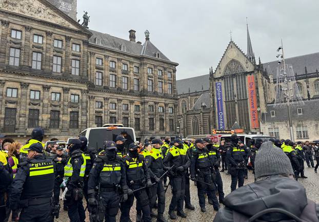 Pro-Palestinian protesters face Dutch police while taking part in a banned demonstration in Amsterdam